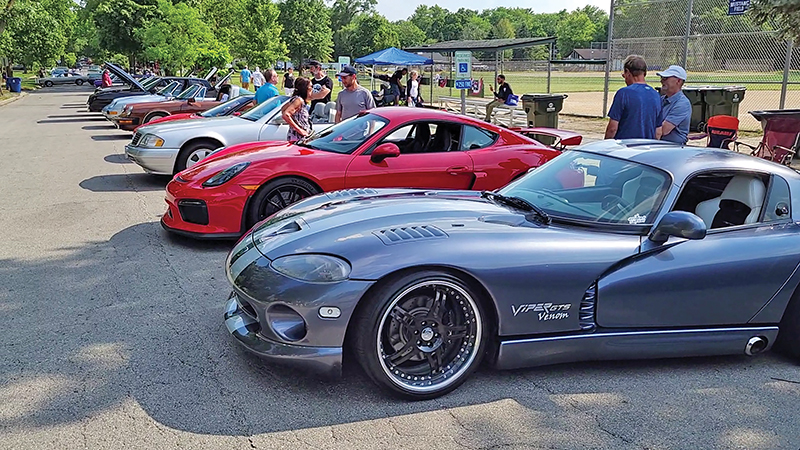 Modern luxury and sports cars along with vintage trucks, autos and one fire truck are lined up along Brassie Avenue for admirers to view during Flossmoor's centennial celebration on June 20. (Eric Crump/H-F Chronicle)