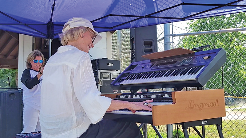 Legendary White Sox organist Nancy Faust performs while Flossmoor Mayor Michelle Nelson captures the moment during Flossmoor's centennial celebration on June 20. (Eric Crump/H-F Chronicle)