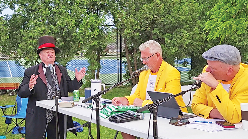 From left, Jim Basala, Terence Smith and Jon Elfner. Basala, umpire for the vintage baseball game, explains the rules to two of the three-member announcing team of the Yellow Jackets. (Eric Crump/H-F Chronicle)
