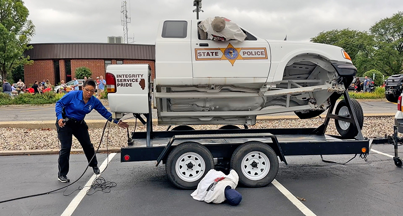 State Trooper Genelle Jones discusses vehicle roll-over results to demonstrate the safety of seatbelts. (Nuha Abdessalam/H-F Chronicle)