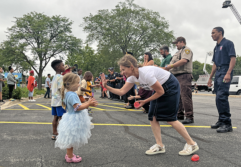 Mayor Michelle Nelson, right, high fives her partner in the balloon toss. (Nuha Abdessalam/H-F Chronicle)