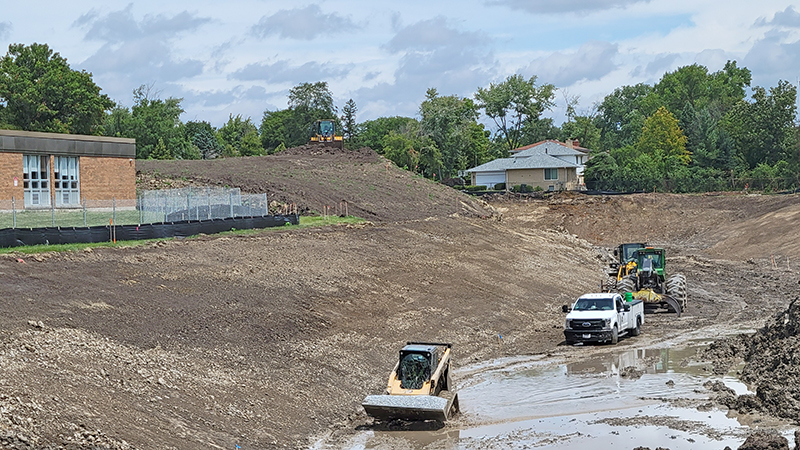 Recent rains make the bottom of the Heather Hill storm basin soggy on July 29. Later in the week, crews were able to start spreading stored top soil in the basin. (Eric Crump/H-F Chronicle)