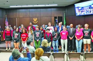 Flossmoor Village Clerk Gina LoGalbo, left, helps Mayor Michelle Nelson, not pictured, recognize at the Sept. 3 board meeting some of the many Homewood-Flossmoor High School students and coaches for their achievements. (Eric Crump/H-F Chronicle)