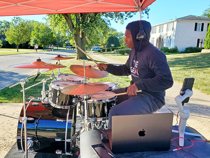 Joseph Robertson plays the drums for Gem runners as they pass. (Chris Weber/H-F Chronicle)