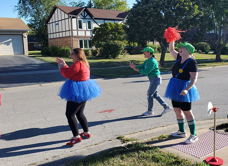 The Mario-themed team cheers on runners. From left, Jenny Fawbush, Avery Orr and Blythe Rudolph. (Chris Weber/H-F Chronicle)