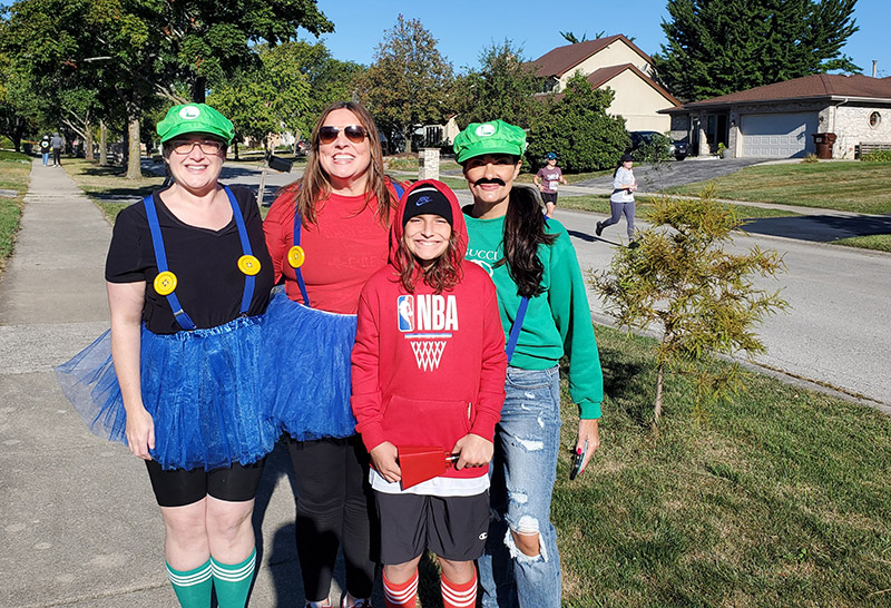 From left, Blythe Rudolph, Jenny Fawbush, Max Bizjak and Alex Orr take a break from cheering runners to pose for a photo. (Chris Weber/H-F Chronicle)