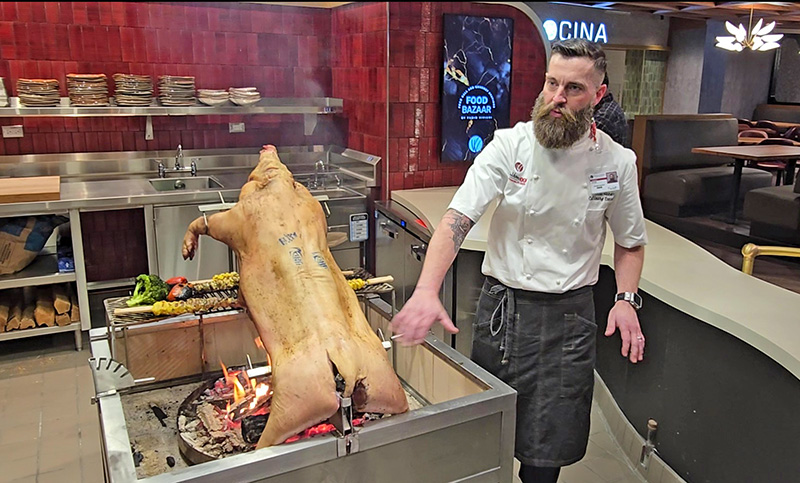 Chef Erik Keever describes the preparation of pork for Southern District, a restaurant in the Wind Creek food bazaar. (Eric Crump/H-F Chronicle)