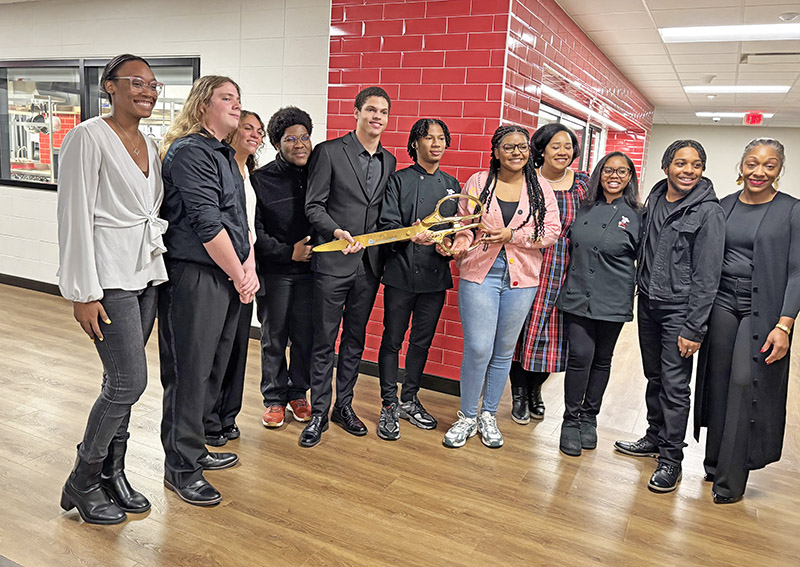 Advanced culinary students prepare for the official ribbon-cutting ceremony at Homewood-Flossmoor High School. Teachers Latasha Scott, at right, and Jontil Grubbs, fourth from right, join students, from left, Khayla Kelley, Theo Cream, Maya Perkins, Hunter Nocentelli, Marcus Argue, Jordan Edgecombe, Alaysia Jennings, Charday Harbour, and Adam Hopper. (Marilyn Thomas/H-F Chronicle)