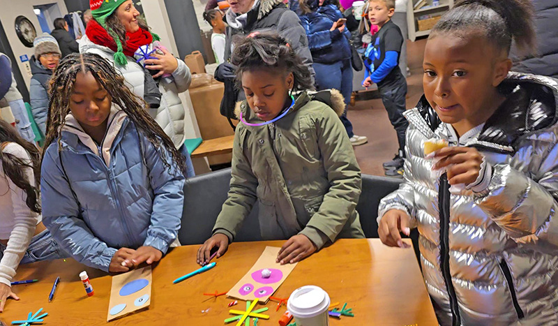 From left, Kelsey Alexander-Wilson, Khylie Carter and Dakota Oglesvy work on creating decorations and enjoy a holiday cupcake in the warming house at Flossmoor's Celebrate the Season event Nov. 30. (Eric Crump/H-F Chronicle)