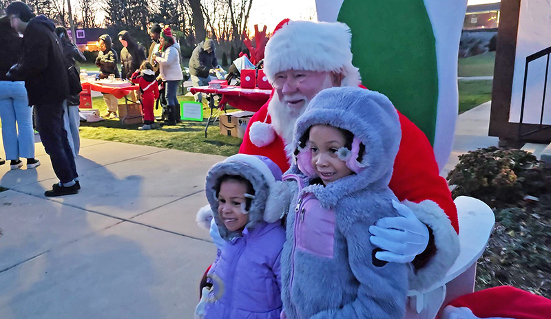 Maleigha, left, and Carsyn Gatling pose for a photo with Santa at Flossmoor's Celebrate the Season event. (Eric Crump/H-F Chronicle)