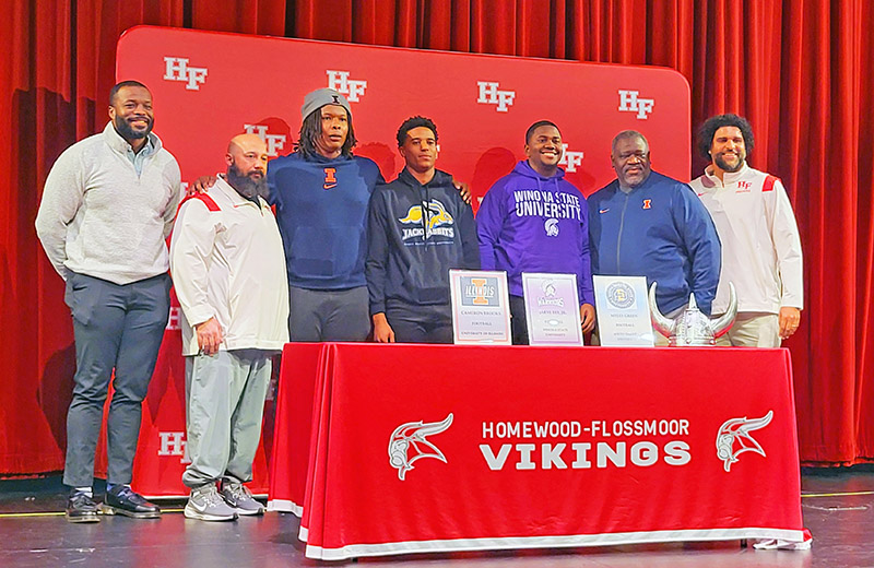 Homewood-Flossmoor football signees pose with coaches after a national letter of intent ceremony at the school Dec. 18. (David P. Funk/H-F Chronicle)