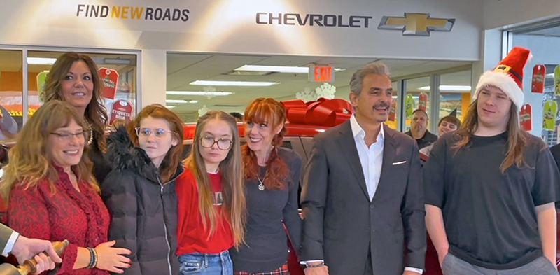 Deanne Recklaus and Homewood Chevrolet owner Steve Phillipos, center, are all smiles after Phillipos presented Reckaus with a new car on Christmas Eve. (Summer Kiswani/H-F Chronicle)