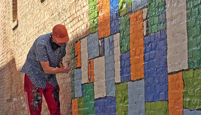 Artist Nate Otto works on Homewood's newest mural on Oct. 29, 2024. (Eric Crump/H-F Chronicle)