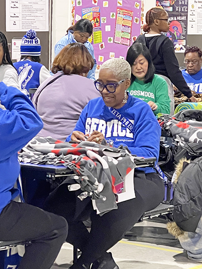 Volunteers make tie blankets for Project Kennedy at Heather Hill Elementary School during the 10th annual MLK Day of Service event in Flossmoor. (Summer Kiswani/H-F Chronicle)