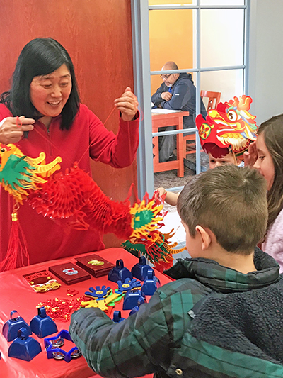 Molly Deugaw, Lunar New Year celebration organizer, greets guests. (Lolita Cusic/H-F Chronicle)