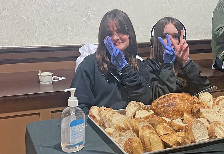 Homewood-Flossmoor High School student Noelle kelly, left, and Emi Hazlet serve sour dough bread made by JustBread at Soup for the Soul. (Nick Ulanowski/H-F Chronicle)