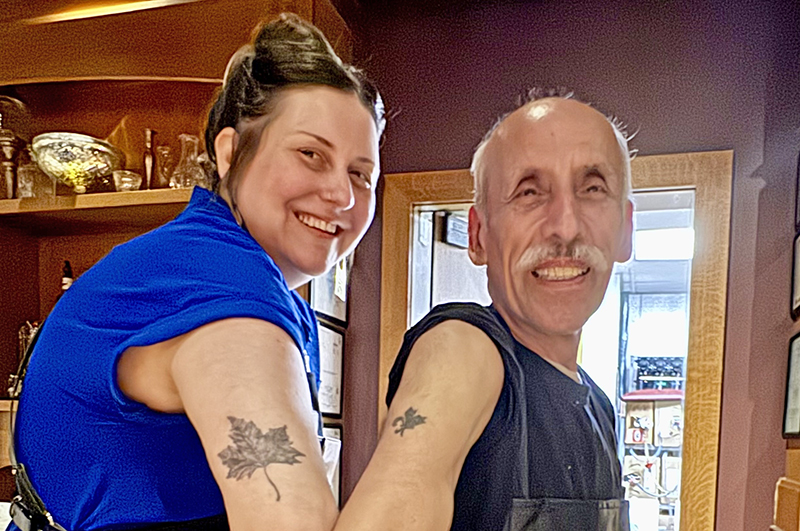 Bar manager Emily Bohn and dishwasher Juan Esparza have been part of the Maple Tree Inn staff for 19 and 30 years respectively. Here they display maple leaf tattoos they and other Maple Tree employees got in solidarity after the Blue Island restaurant burned down. (Karen Torme Olson/H-F Chronicle)