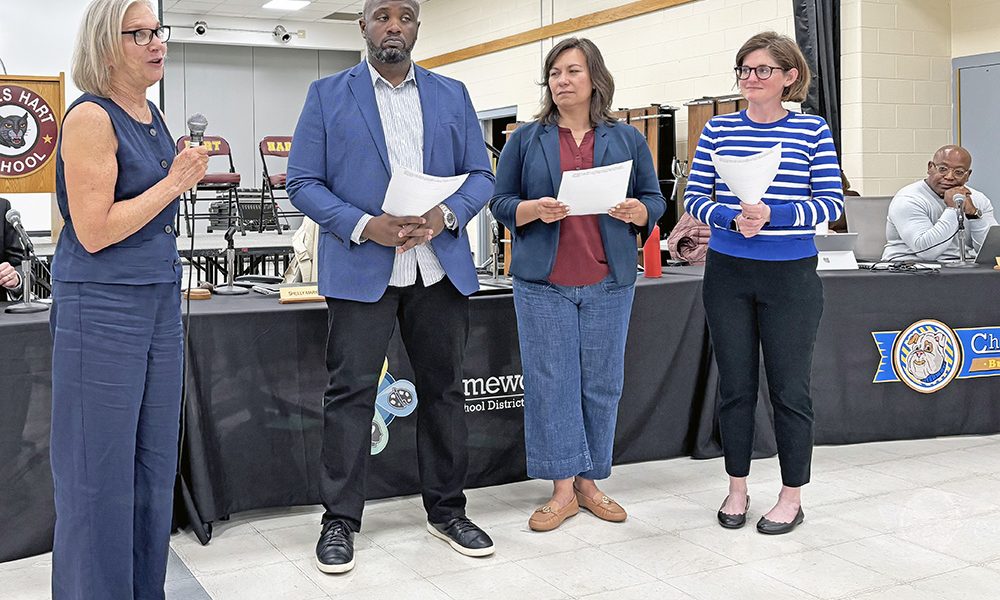 Outgoing board president Shelly Marks, left, leads newly elected board members Roderick Booth, Becky Popelka and Christine Scully in their oath of office at the May 5 District 153 board meeting. (Marilyn Thomas/H-F Chronicle)