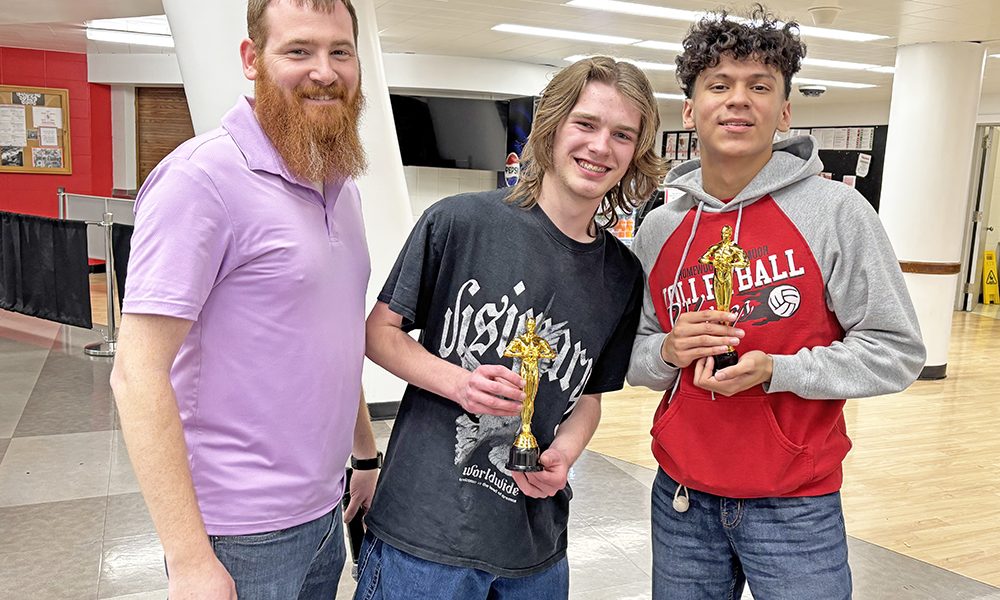 Teacher Matt McLindon, left, congratulates students Aidan Klauk, center, and Anthony Reynoso, winners of the Audience Choice Award for their short film "The Thread." It was one of 16 short films produced by Homewood-Flossmoor students shown during the first Viking Film Festival May 9. (Marilyn Thomas/H-F Chronicle)