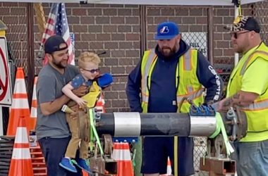 A boy gets an up-close look as Homewood Public Works crew members demonstrate how to tighten a leaking pipe. (Summer Kiswani/H-F Chronicle)