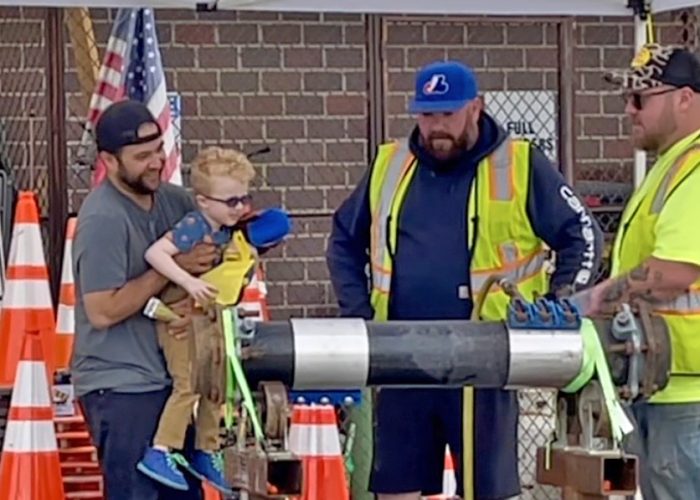 A boy gets an up-close look as Homewood Public Works crew members demonstrate how to tighten a leaking pipe. (Summer Kiswani/H-F Chronicle)