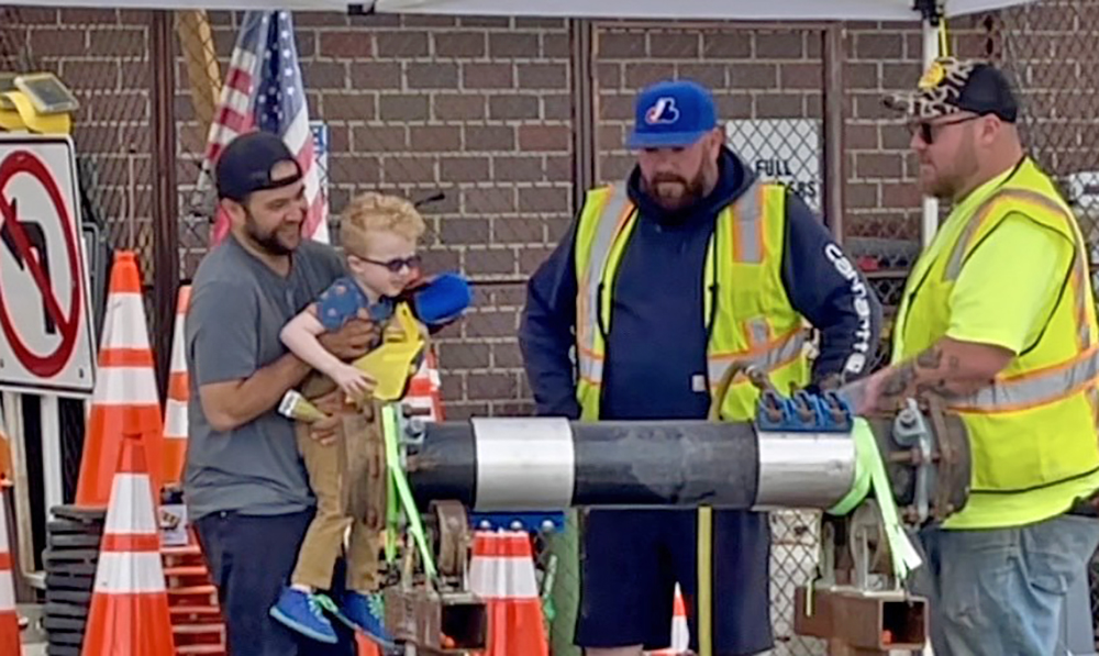 A boy gets an up-close look as Homewood Public Works crew members demonstrate how to tighten a leaking pipe. (Summer Kiswani/H-F Chronicle)
