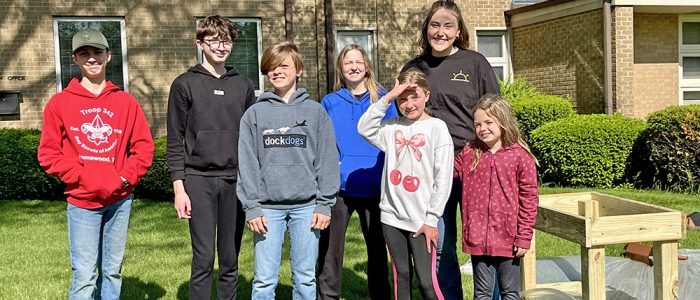 Korey Ziemkowski and the kids smile for a photo before kicking off the pantry build at Salem Lutheran Church in Homewood. (Nuha Abdessalam/H-F Chronicle)