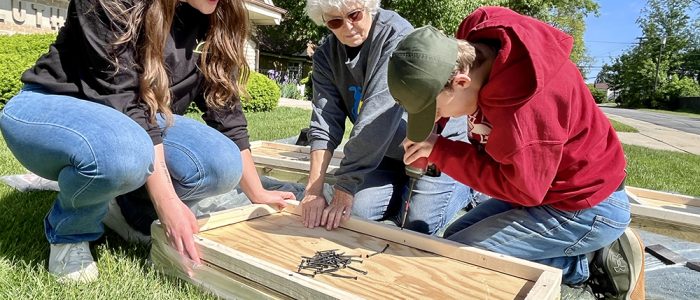 Korey Ziemkowski and Lorie Zoellick walk Jacob Davis through pantry assembly during Saturday’s build at Salem Lutheran Church in Homewood. (Nuha Abdessalam/H-F Chronicle)