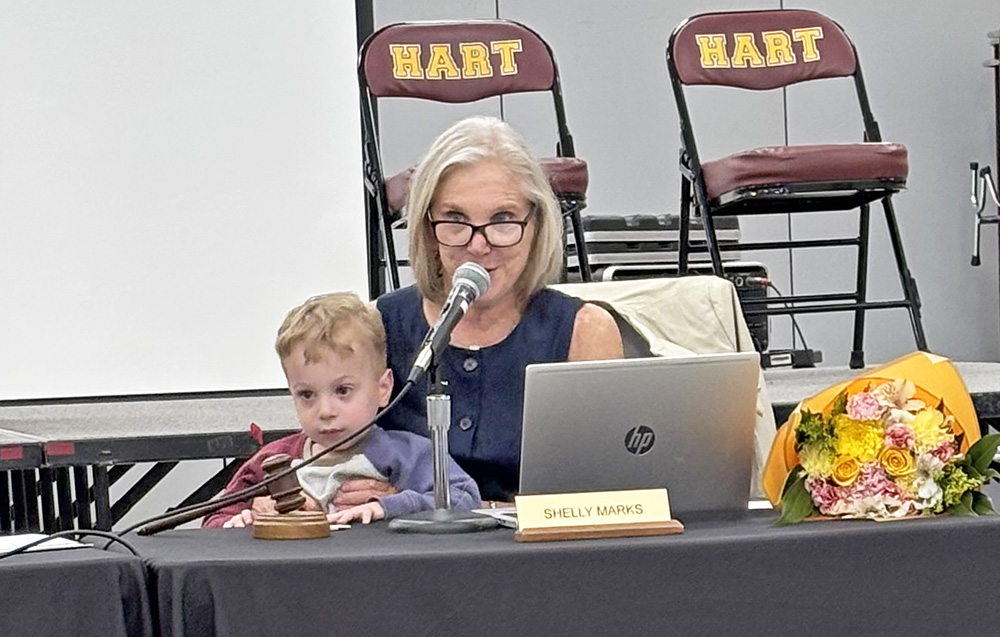 Jonah Marks, 3, got to gavel the start of the District 153 school board meeting with his grandmother Shelly Marks. It was her last meeting after serving for 33 years. (Marilyn Thomas/H-F Chronicle)
