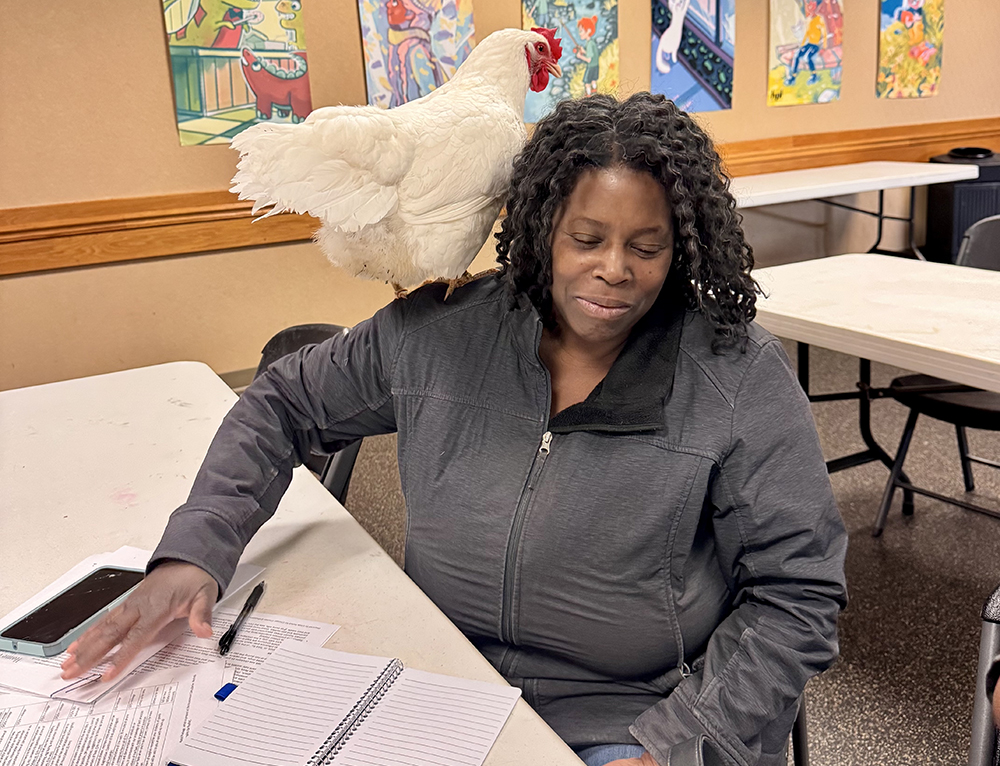 Sandy gets a birds-eye view of Tracy Woodson’s notes during Jennifer Murtoff’s chicken-keeping seminar at the Homewood Library May10. (Karen Torme Olson/H-F Chronicle)