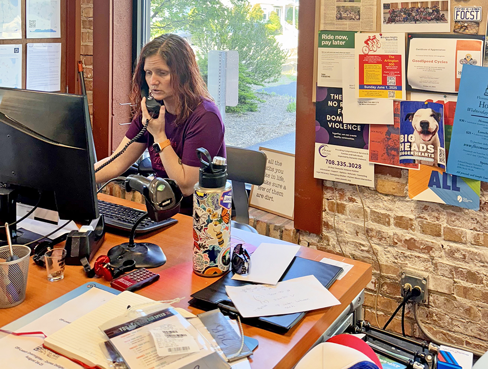 Alyss Bolkema takes a customer call at GoodSpeed. She said she is easing her way back into the operation after taking time off for her children, Adaahlyn, 10, and Warren, 9. Besides bike business, GoodSpeed sponsors numerous fundraisers and initiatives like the “All Kids Bike program for kindergarteners at Willow School. “Helping people is just who we are,” she said. (Karen Torme Olson/H-F Chronicle)
