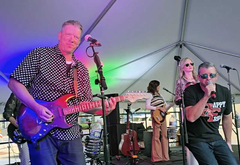 Jon Elfner, left, plays guitar while Ted Venegas sings as Not My Dad and the South Side Horns play the final set of the Art & Garden Fair on Friday, June 6. (Eric Crump/H-F Chroncile)