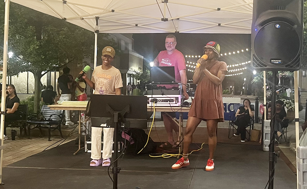 Loraine Hamlett, left, and her friend Jasmine Jones sing karaoke at Rock the Block. (Nick Ulanowski / H-F Chronicle)