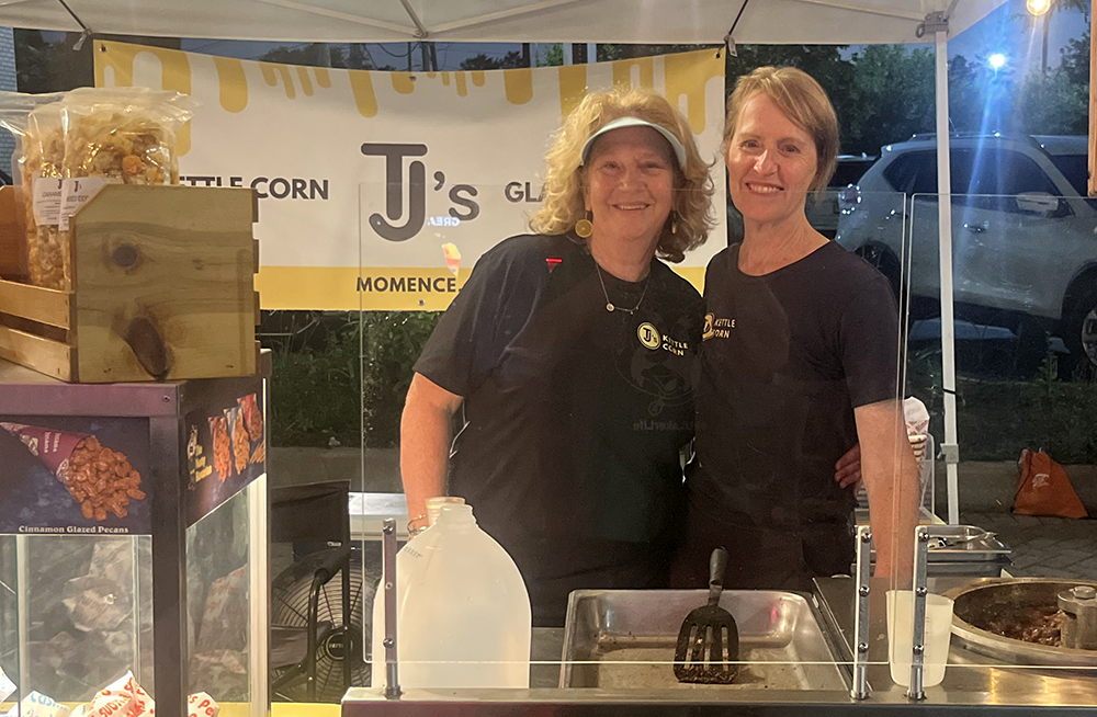 Betsy Cienkus, left, and Lorrie Tempco operate the TJ’s Kettle Corn booth. (Nick Ulanowski / H-F Chronicle)