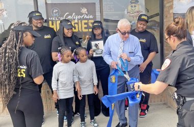 Mayor Rich Hofeld cuts the blue ribbon into smaller pieces. Mel’s California Hoagies owners, Mel Lee, upper left, and Tudy Lee, second from left, look on. (Nick Ulanowski / H-F Chronicle)