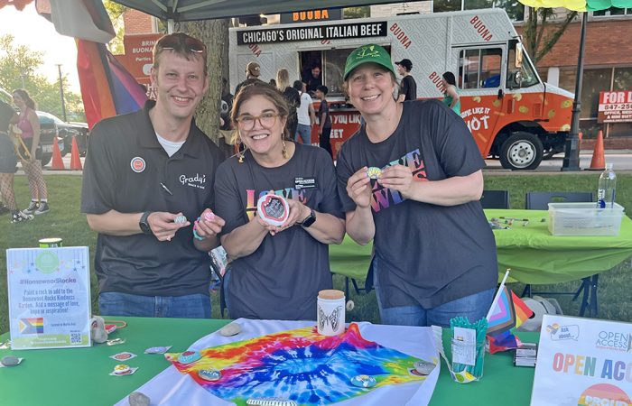 From left, Grady’s Snack N Dine manager Ian Woith; Dodi Wians, director of development and community relations for Open Access; and Kristen Ryan of Open Access work a booth shared by the Homewood Business Association and Open Access during H-F Pride Fest. (Nick Ulanowski/H-F Chronicle)