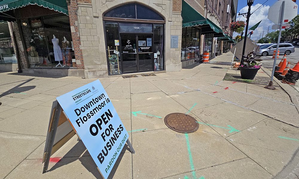 A sign at the corner of Flossmoor and Sterling roads reminds visitors that downtown shops will remain open during the streetscape construction work this summer. The village built requirements in the contract to ensure business disruption would be kept to a minimum. (Eric Crump/H-F Chronicle)