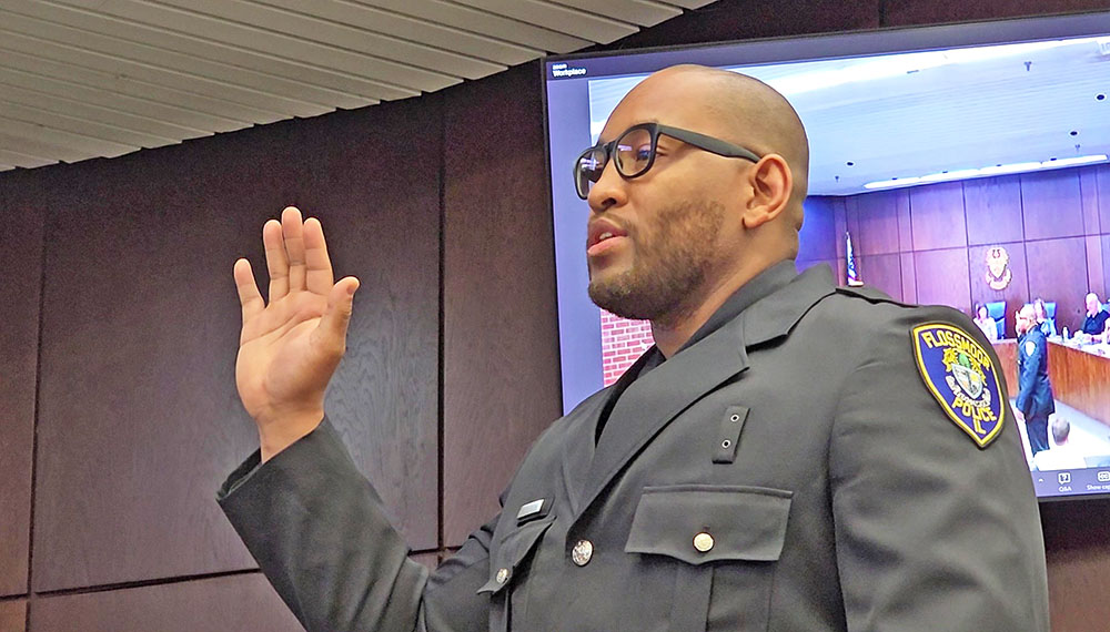 Police Officer Anoribe Nwannewuihe takes the oath of office at the Flossmoor board meeting on July 21. (Eric Crump/H-F Chronicle)
