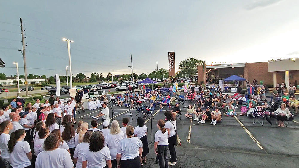 Bel Canto Community Choir perfoorms at Chamber Night on Thursday, July 24, as storm clouds approach from the southwest. At the conclusion of the group's set, Chicago Southland Chamber of Commerce Executive Director Jennel Hooper announced the early end to the event because of lightning in the area. (Eric Crump/H-F Chronicle)