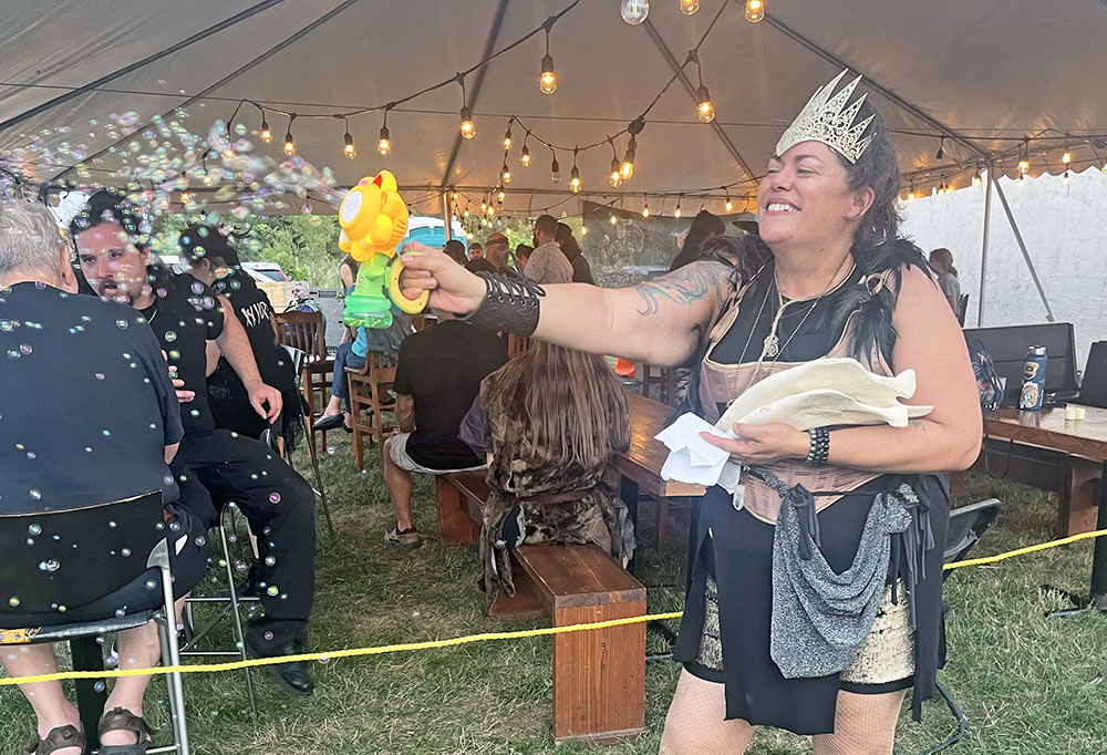 Rabid Brewing co-owner Raiye Rosado blows bubbles into the crowd with a bubble-making device during the Feast of the Goat Queen on July 26. (Nick Ulanowski / H-F Chronicle)