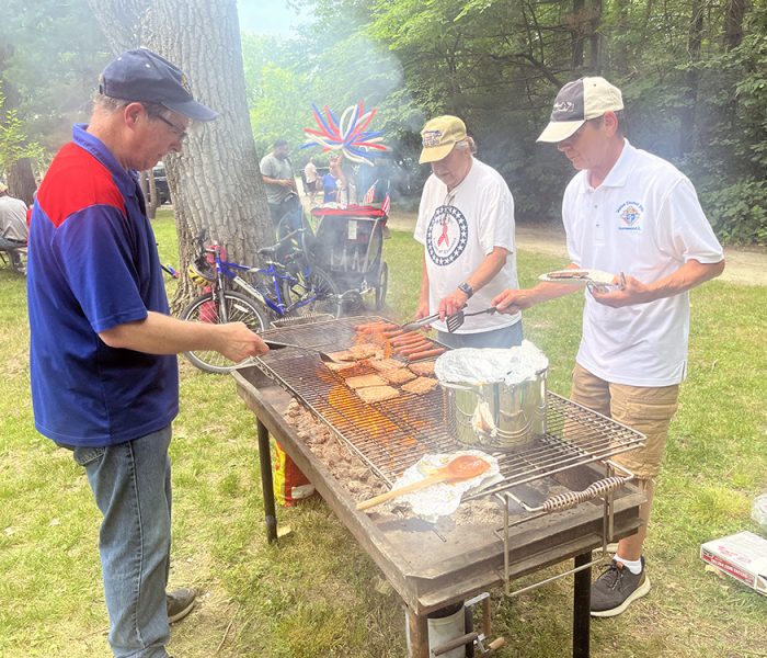 Knights of Columbus members Paul Lynch, left, Scott Troxel, center, and Richard Mantoan grill food for community members at the Izaak Walton picnic. (Nick Ulanowski / H-F Chronicle)