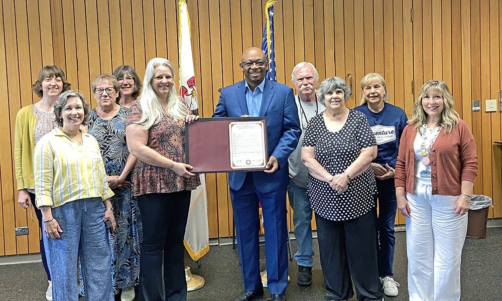 Rep. Will Davis, D-Homewood, center, presents the staff of the Homewood Public Library an official proclamation celebrating the library's 100th anniversary. Joining Davis are, from left, Kate Arnold, Leslie Stark, Juanita Nutting, Margaret Novak, Karin Gerson, Brian Bell, Susan Norman, Kathy Tisoncik and Lisa Stilts. (Provided photo)