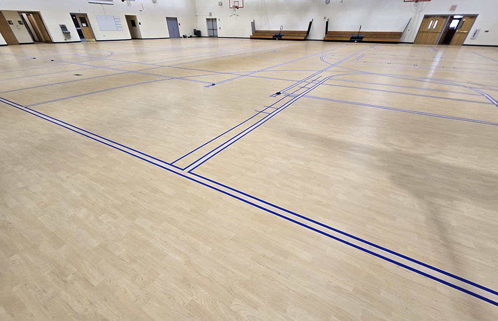 The newly laid floor in the Sports Complex has markings for basketball, volleyball and badminton. (Provided photo)
