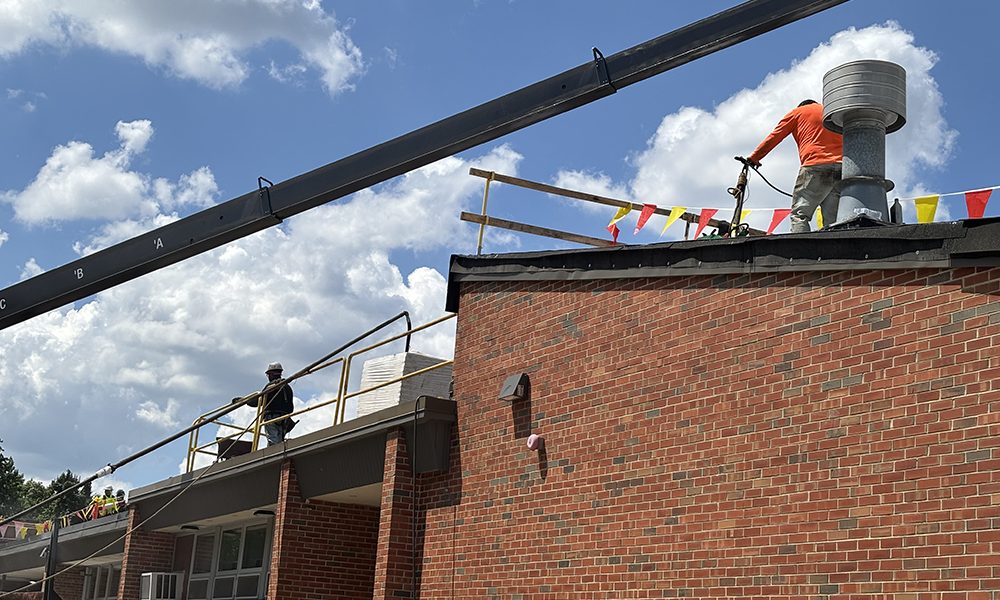 Crew members from CDF Roofing work under the hot sun tarring a section of the Willow School roof in Homewood. (Marilyn Thomas/H-F Chronicle)