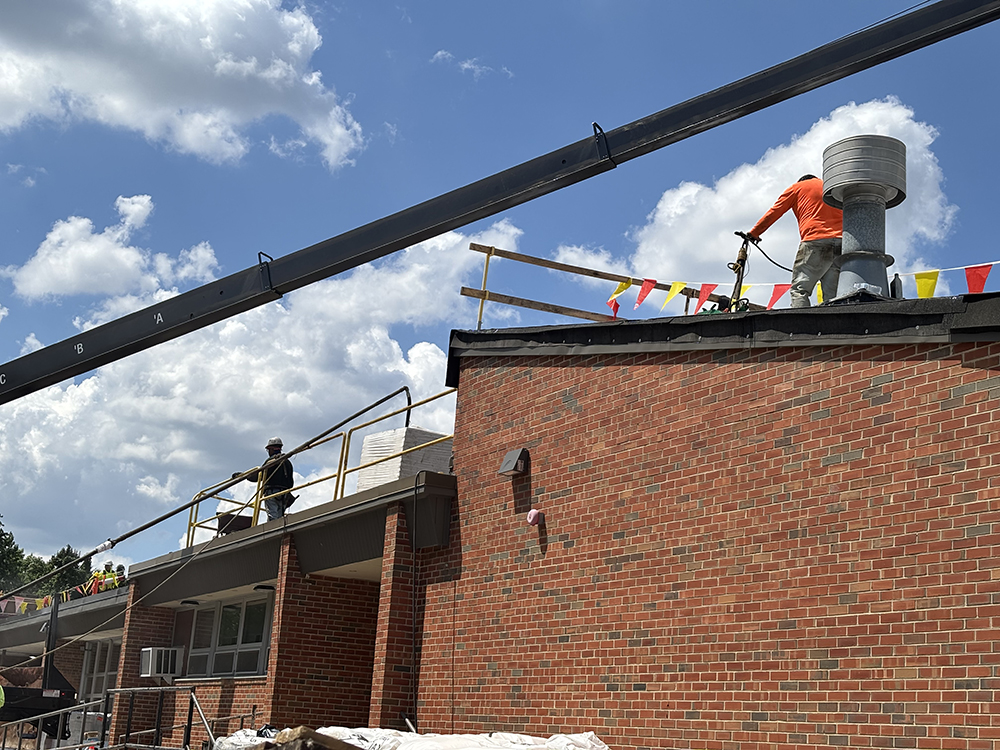 Crew members from CDF Roofing work under the hot sun tarring a section of the Willow School roof in Homewood. (Marilyn Thomas/H-F Chronicle)