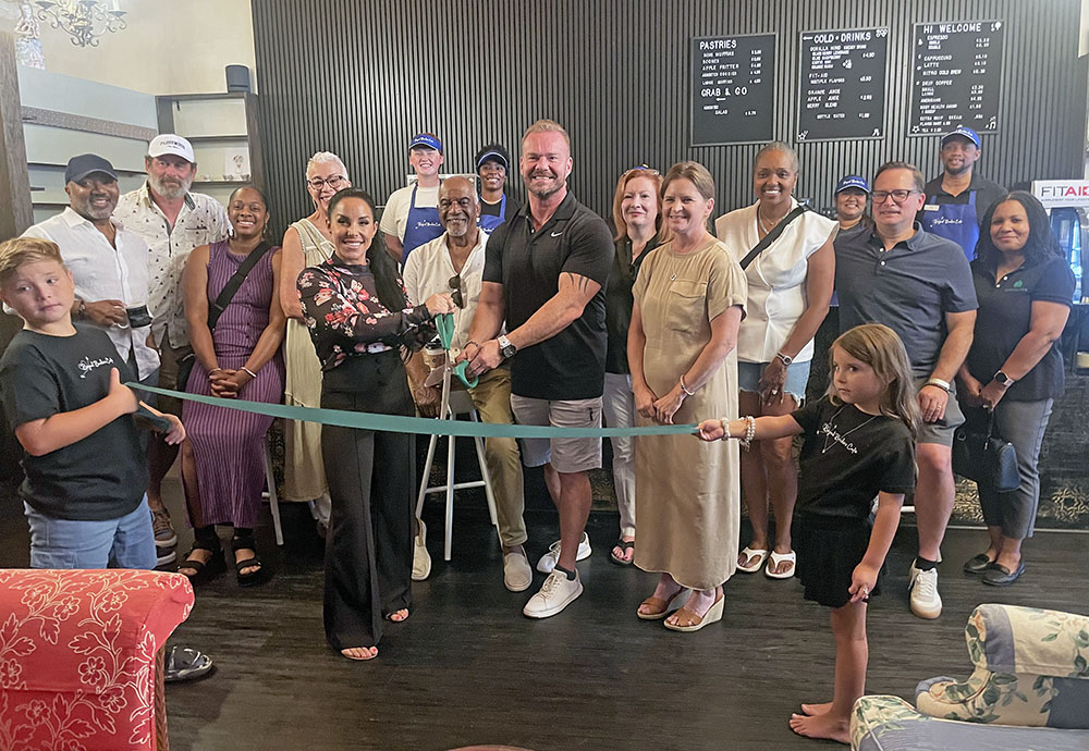 Owners Christopher and Jennifer Zarozny joined by Flossmoor Mayor Michele Nelson, village trustees, their children and employees cut the ribbon to officially open Beyond Borders Cafe on Saturday, Aug. 9. (Jamilah Lewis/H-F Chronicle)
