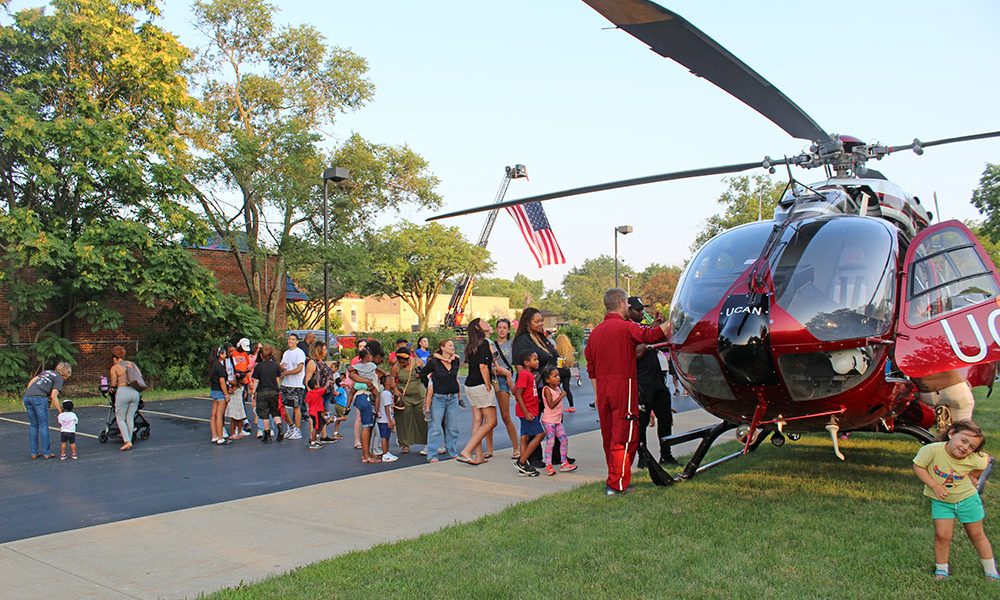A line forms as kids and adults waited their turn to sit inside the UCAN helicopter during National Night Out in Flossmoor. (Nuha Abdessalam/H-F Chronicle)