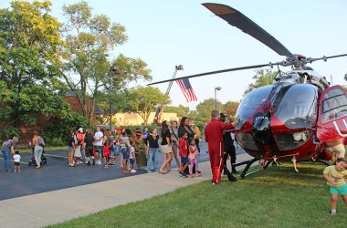 A line forms as kids and adults waited their turn to sit inside the UCAN helicopter during National Night Out in Flossmoor. (Nuha Abdessalam/H-F Chronicle)