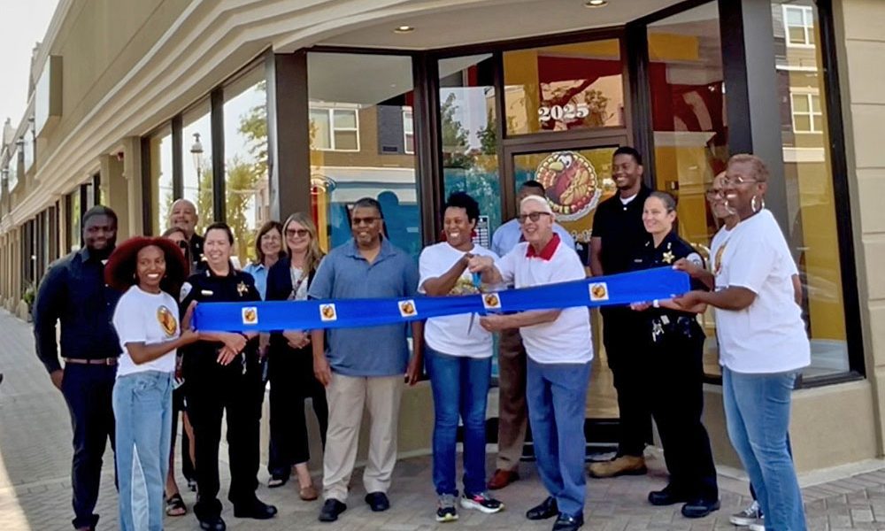 Annah Mitchell, center, owner of Gobble Doggs, cuts the ribbon with Homewood Mayor Rich Hofeld to officially open the hot dog restaurant on Ridge Road. (Summer Kiswani/ H-F Chronicle)