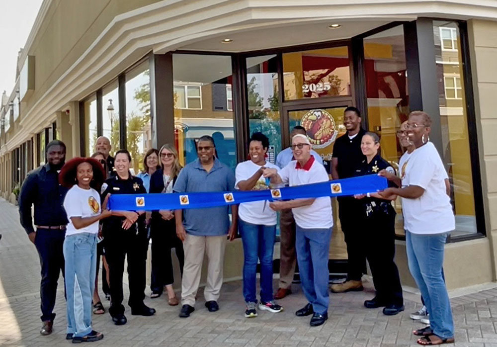 Annah Mitchell, center, owner of Gobble Doggs, cuts the ribbon with Homewood Mayor Rich Hofeld to officially open the hot dog restaurant on Ridge Road. (Summer Kiswani/ H-F Chronicle)